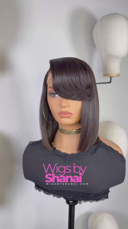 Woman wearing sleek 12-inch side-part bob wig with swoop bang in natural black, styled straight and smooth.