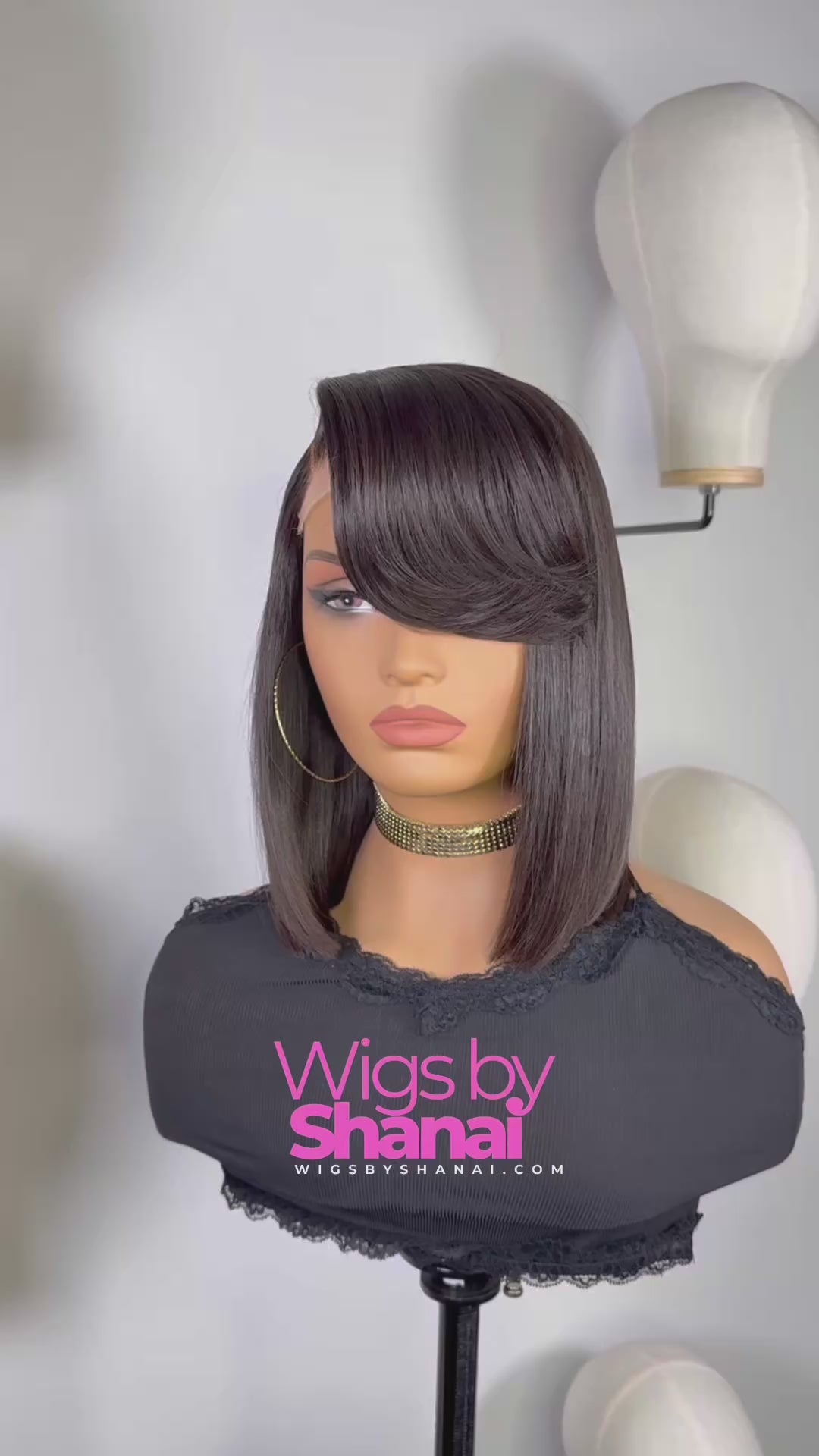 Woman wearing sleek 12-inch side-part bob wig with swoop bang in natural black, styled straight and smooth.